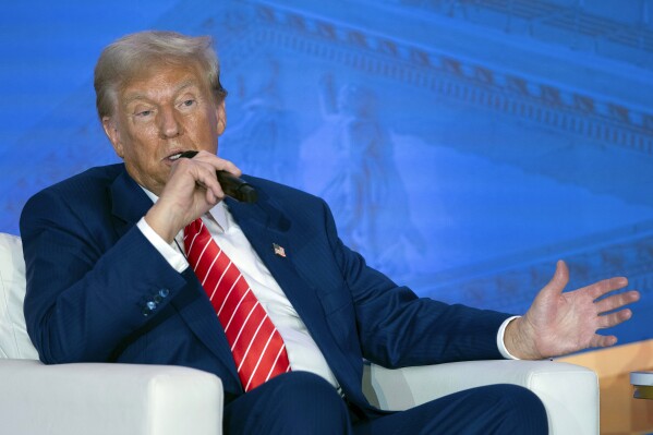 Republican presidential nominee former President Donald Trump speaks with Moms for Liberty co-founder Tiffany Justice during an event at the group's annual convention in Washington, Friday, Aug. 30, 2024. (AP Photo/Jose Luis Magana)