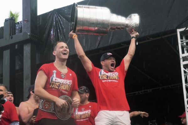Florida Panthers' Matthew Tkachuk, left, and Kyle Okposo, right, celebrate with the Stanley Cup during an NHL hockey parade and rally, Sunday, June 30, 2024, in Fort Lauderdale, Fla. The Panthers defeated the Edmonton Oilers to win the championship series. (AP Photo/Marta Lavandier)