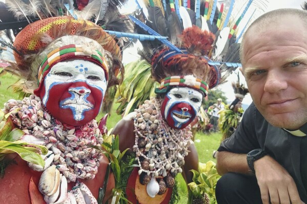 This undated photo provided by Fr Tomas Ravaioli shows local villagers posing for a photo with him in Goroka, Papua New Guinea. (Fr Tomas Ravaioli via AP)