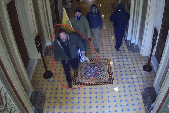 This image from U.S. Capitol Police video, released and annotated by the Justice Department in the statement of facts supporting an arrest warrant for Bradley Scott Nelson, shows Nelson, circled in red, at the U.S. Capitol on Jan. 6, 2021, in Washington. (Justice Department via AP)