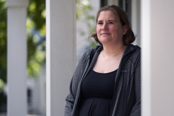 Rebecca Wood stands for a portrait outside her home, Friday, Aug. 30, 2024, in Maynard, Mass. Wood noticed a "program fee" required each time she loaded money onto her daughter's school lunch account. (AP Photo/Charles Krupa)