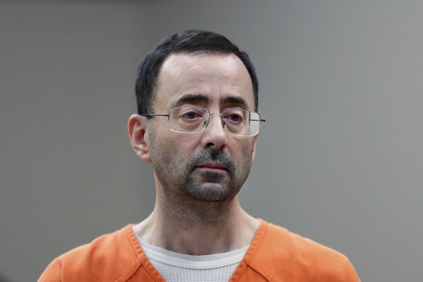 FILE - Disgraced former sports doctor Larry Nassar appears in court for a plea hearing, Nov. 22, 2017, in Lansing, Mich. (AP Photo/Paul Sancya, File)