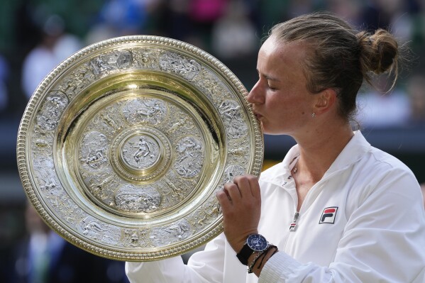 Barbora Krejcikova of the Czech Republic kisses her trophy after defeating Jasmine Paolini of Italy in the women's singles final at the Wimbledon tennis championships in London, Saturday, July 13, 2024. (AP Photo/Kirsty Wigglesworth)