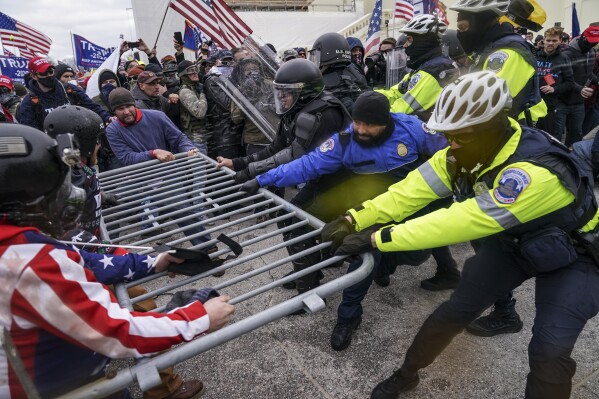 FILE - Supporters of President Donald Trump try to break through a police barrier, Jan. 6, 2021, during a riot at the Capitol in Washington. Former President Donald Trump said during a debate with President Joe Biden last week that the attack on the Capitol involved a "relatively small" group of people who were "in many cases ushered in by the police." (AP Photo/John Minchillo)