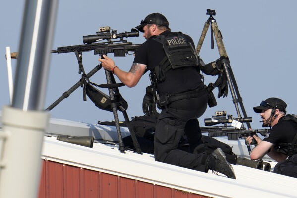 Police snipers return fire after shots were fired while Republican presidential candidate former President Donald Trump was speaking at a campaign event in Butler, Pa., on Saturday, July 13, 2024. (AP Photo/Gene J. Puskar)