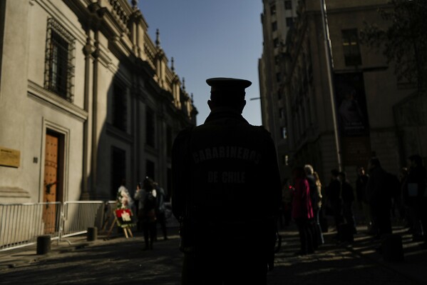 A police officer stands guard by the eastern entrance of La Moneda presidential palace on the anniversary of the 1973 military coup in Santiago, Chile, Wednesday, Sept. 11, 2024. It was through this entrance that President Salvador Allende's body was carried away 51 years ago and began the dictatorship of Gen. Augusto Pinochet. (AP Photo/Esteban Felix)