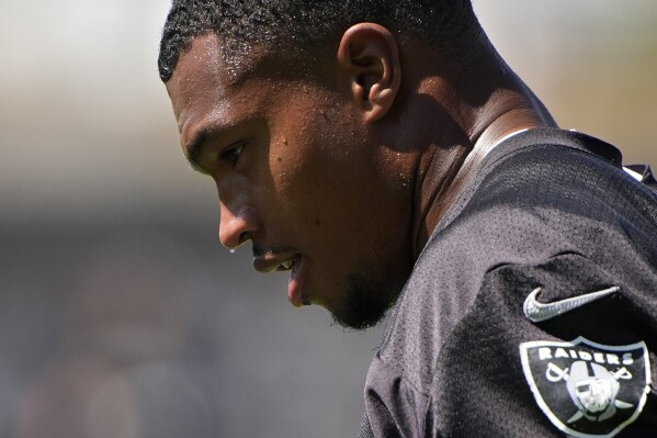 Las Vegas Raiders defensive end Tyree Wilson (9) sweats as he warms up during NFL football practice Tuesday, June 4, 2024, in Henderson, Nev. (AP Photo/John Locher)