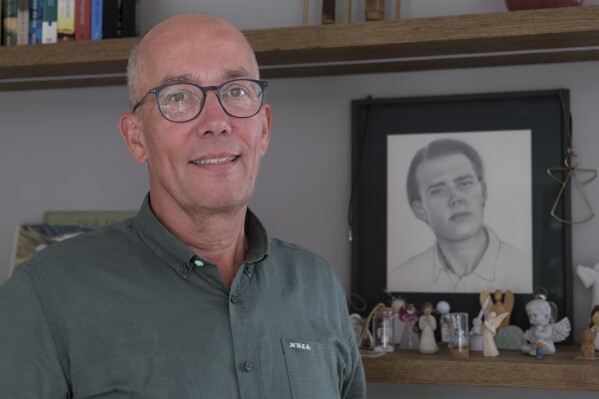 Thomas Schansman poses in front of a drawing of his son, Quinn, at his home in the central Dutch city of Hilversum, Netherlands, Thursday, July 11, 2024. Quinn Schansman dreamed of becoming the youngest ever CEO of an American company. But the 18-year-old dual Dutch-American citizen's future — whatever it may have held — was cruelly cut short when he was one of the 298 people killed as a Soviet-era Buk surface-to-air rocket launched from territory in eastern Ukraine controlled by pro-Russian rebels destroyed Malaysia Airlines Flight MH17. (AP Photo/Michael Corder)