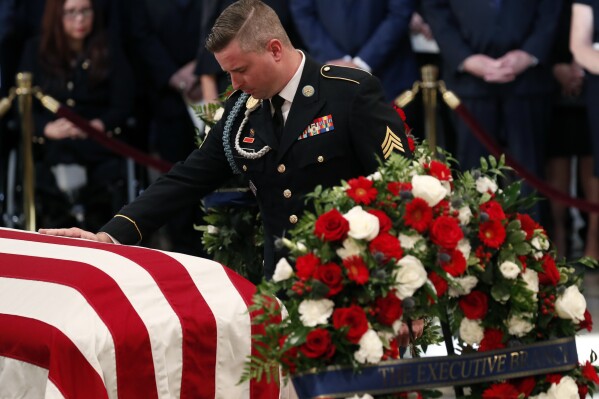 FILE - Jimmy McCain, son of Sen. John McCain, R-Ariz., pauses at his father's casket during ceremonies honoring McCain at the U.S. Capitol Rotunda in Washington, Aug. 31, 2018. Jimmy McCain has registered as a Democrat and will vote for Kamala Harris for President in 2024. (Kevin Lamarque/Pool Photo via AP)