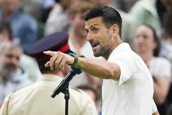 Novak Djokovic of Serbia gestures to the crowd as he is interviewed after defeating Holger Rune of Denmark in their fourth round match at the Wimbledon tennis championships in London, Monday, July 8, 2024.(AP Photo/Kirsty Wigglesworth)