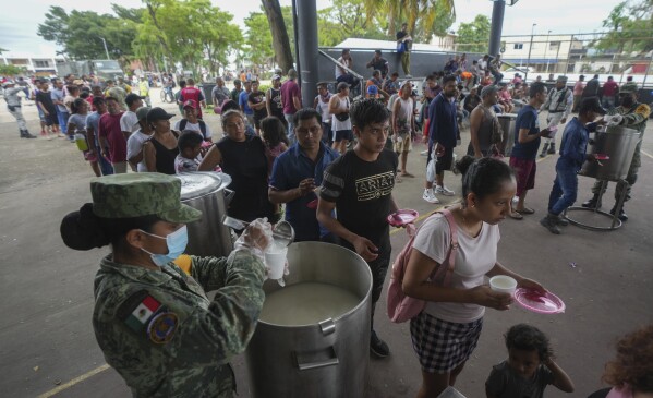 People line up to receive food at an army-provided soup kitchen for those impacted by Hurricane Beryl in Tulum, Mexico, July 5, 2024. (AP Photo/Fernando Llano)