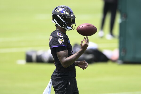 Baltimore Ravens quarterback Lamar Jackson spins the football on his finger during an NFL football practice, Tuesday, June 11, 2024, in Owings Mills, Md. (AP Photo/Nick Wass)