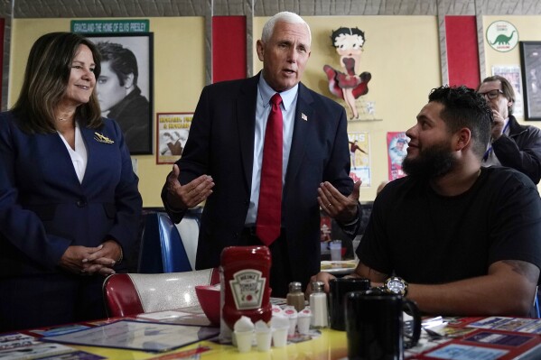 FILE - Republican presidential candidate former Vice President Mike Pence and his wife Karen, left, chat with a patrons during a campaign stop at a diner, June 9, 2023, in Derry, N.H. Weary Republicans who acknowledge Donald Trump's dominance, across New Hampshire are fighting to stop the former president from winning the first-in-the-nation primary. For now, however, they're relying on little more than hope and prayers. Look no further than Pence, who repeatedly appealed to voters' faith as he tried to resurrect his anemic presidential campaign while courting a few dozen voters in a former state lawmaker's backyard. (AP Photo/Charles Krupa, File)