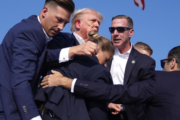 Republican presidential candidate former President Donald Trump is surrounded by U.S. Secret Service agents at a campaign rally, Saturday, July 13, 2024, in Butler, Pa. (AP Photo/Evan Vucci)