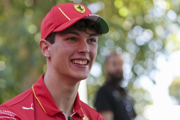 FILE - Ferrari reserve driver Oliver Bearman of Britain is interviewed outside his team garage ahead of the Australian Formula One Grand Prix at Albert Park, Melbourne, Australia, Thursday, March 21, 2024. Haas announced the signing in a statement Thursday, July 4, without giving more details. The 19-year old British driver will take the seat vacated by German driver Nico Hulkenberg, who is joining Sauber at the end of the year ahead of its rebranding to Audi for 2026. (AP Photo/Asanka Brendon Ratnayake, File)