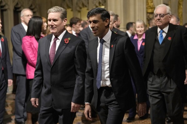 FILE - Britain's then-Prime Minister Rishi Sunk, right, and Labour Party leader Keir Starmer pass through the Peer's Lobby to attend the State Opening of Parliament, at the Palace of Westminster in London, Tuesday, Nov. 7, 2023. King Charles III will officially open the new session of Parliament on Wednesday, July 17, 2024, donning his ceremonial robes and the crown of state to deliver a speech laying out the legislative program of the U.K.’s first left-leaning government in 14 years. (AP Photo/Alastair Grant, Pool, File)