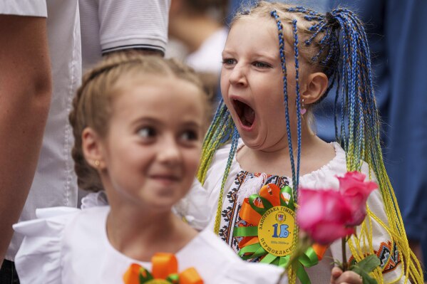 Children attend the traditional ceremony for the first day of school in Zaporizhzhia, Ukraine, Sunday Sept. 1, 2024. Zaporizhzhia schoolchildren celebrated the traditional first day of school near the frontline. With the front just 40 kilometers away, the war is never far from the minds of teachers and families. (AP Photo/Evgeniy Maloletka)