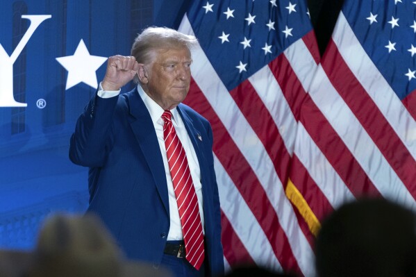 Republican presidential nominee former President Donald Trump gestures as he leaves after speaking with Moms for Liberty co-founder Tiffany Justice during an event at the group's annual convention in Washington, Friday, Aug. 30, 2024. (AP Photo/Jose Luis Magana)