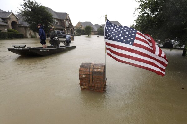 
              Volunteers use their boat to help evacuate residents as floodwaters from Tropical Storm Harvey rise Monday, Aug. 28, 2017, in Spring, Texas. (AP Photo/David J. Phillip)
            