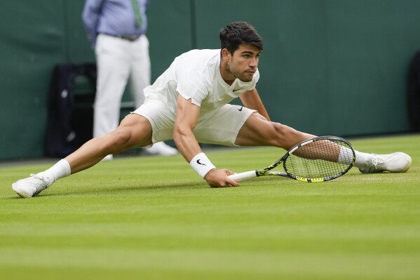 Carlos Alcaraz of Spain plays a forehand return to Ugo Humbert of France during their fourth round match at the Wimbledon tennis championships in London, Sunday, July 7, 2024. (AP Photo/Alberto Pezzali)