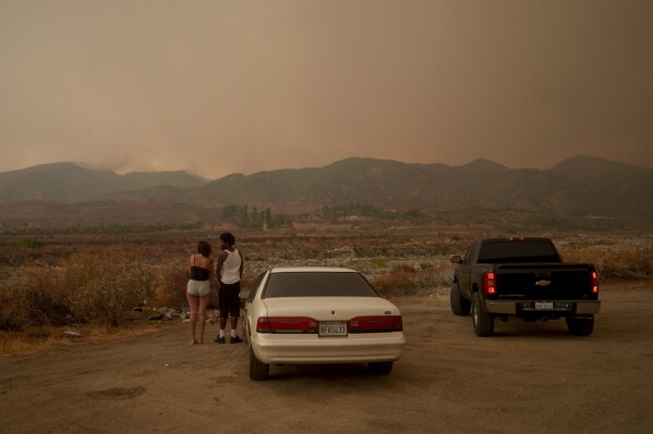 People watch as the Line Fire advances in Mentone, Calif., Sunday, Sept. 8, 2024. (AP Photo/Eric Thayer)