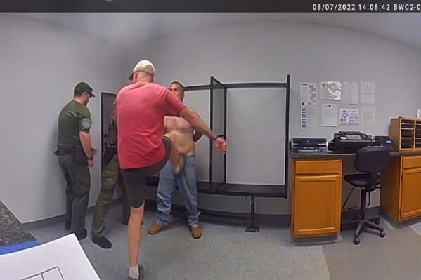 FILE - In this image taken from surveillance video provided by the Franklin County, Vt., sheriff's office, then-Sheriff Department Capt. John Grismore, at center wearing shorts, apparently kicks a handcuffed and shackled detainee in the groin on Aug. 7, 2022, in St. Albans, Vt. Grismore. (Franklin Co., Vt. Sheriff's Department via AP, File)