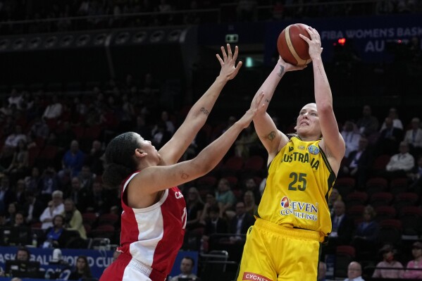 FILE - Australia's Lauren Jackson shoots over Canada's Natalie Achonwa during the bronze medal game at the women's Basketball World Cup in Sydney on Oct. 1, 2022. Basketball star Lauren Jackson will compete at her fifth Olympics after being selected in Australia’s 12-player squad on Sunday, July 7, 2024 just four months after again coming out of retirement. (AP Photo/Rick Rycroft, File)