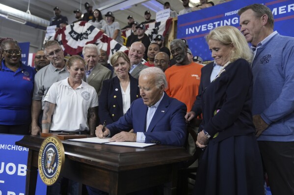 President Joe Biden participates in a signing ceremony after speaking to labor union members about his Investing in America agenda during a visit to the U.A. Local 190 Training Center in Ann Arbor, Mich., Friday, Sep. 6, 2024, as Rep. Debbie Dingell, D-Mich., right, looks on. (AP Photo/Manuel Balce Ceneta)