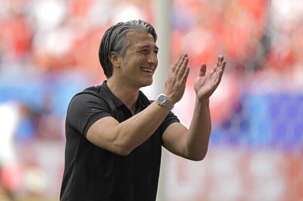 Switzerland's head coach Murat Yakin reacts to the fans before the start of the quarterfinal match between England and Switzerland at the Euro 2024 soccer tournament in Duesseldorf, Germany, Saturday, July 6, 2024. (AP Photo/Thanassis Stavrakis)