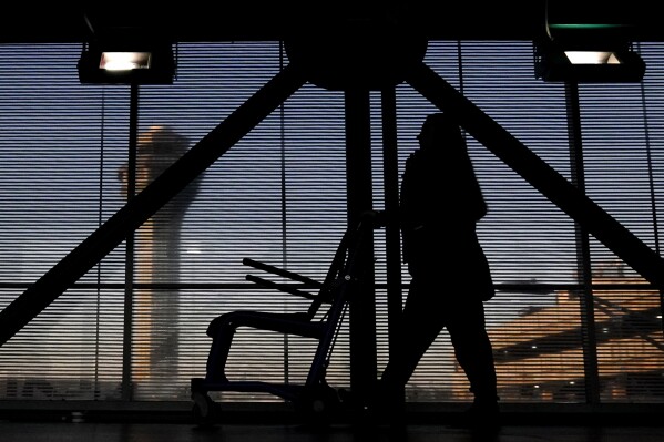 FILE - An airline employee transfers a wheelchair to her station at O'Hare International Airport in Chicago, Nov. 23, 2022. The Biden administration will propose Thursday, Feb. 29, 2024, to make it easier for the government to fine airlines for damaging or misplacing wheelchairs by making it an automatic violation of a federal law on accessible air travel. (AP Photo/Nam Y. Huh, File)