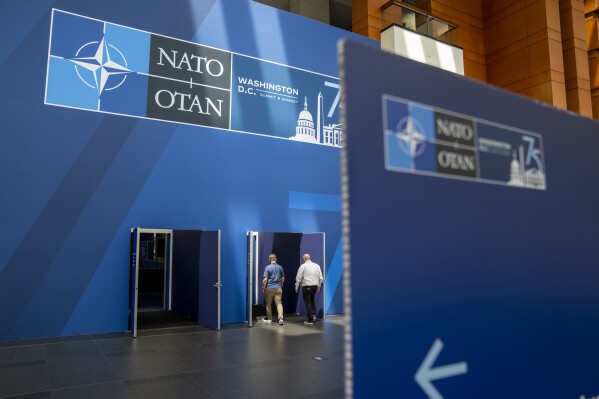 People walk inside of the Walter E. Washington Convention Center, which has been decorated with signage in preparation for the NATO Summit, Monday, July 8, 2024. New Zealand, Japan, South Korea and Australia are sending leaders or their deputies to the NATO summit in Washington this week as the military alliance shows growing interest beyond Europe and the Western Hemisphere. (AP Photo/Jacquelyn Martin)