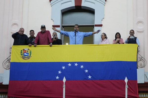 President Nicolas Maduro gestures to supporters during a speech from the presidential palace in defense of his reelection, in Caracas, Venezuela, Tuesday, July 30, 2024. (AP Photo/Fernando Vergara)