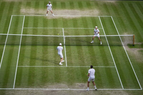 Australia's Max Purcell and compatriot Jordan Thompson, top, in action against Harri Heliovaara of Finland and Henry Patten, bottom, of Britain in the men's doubles final at the Wimbledon tennis championships in London, Saturday, July 13, 2024. (AP Photo/Kirsty Wigglesworth)