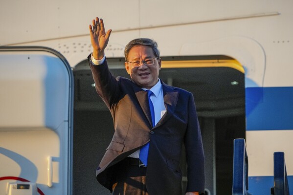 Chinese Premier Li Qiang waves on his arrival at Adelaide Airport, Australia, Saturday, June 15, 2024. Li is on a relations-mending mission with panda diplomacy, rock lobsters and China's global dominance in the critical minerals sector high on the agenda during his four day visit to Australia. (Asanka Brendon Ratnayake/Pool Photo via AP)