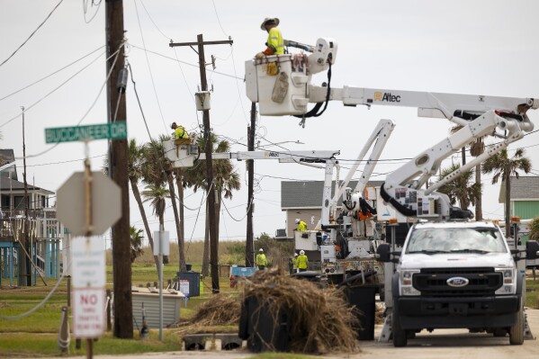 Linemen repair power lines on Jamaica Beach Road the west beach of Galveston Island on Saturday, July 13, 2024. (AP Photo/Annie Mulligan)