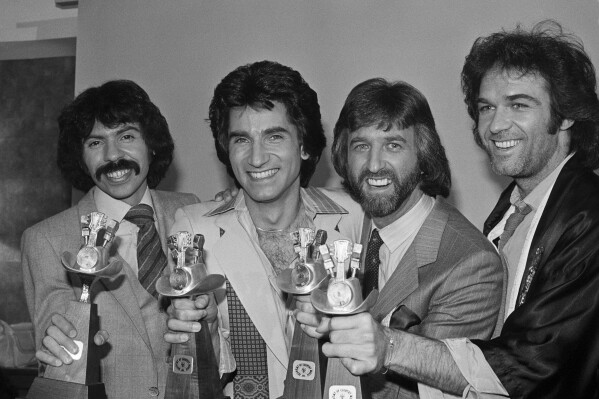 FILE - The Oak Ridge Boys, from left, Joe Bonsall, Richard Sterban, Duane Allen and William Lee Golden hold their awards for Top Vocal Group and Best Album of the Year for "Ya'll Come Back Saloon", during the 14th Annual Academy of Country Music Awards in Los Angeles, Calif., May 3, 1979. Bonsall died on Tuesday, July 9, 2024, from complications of Amyotrophic Lateral Sclerosis in Hendersonville, Tenn. He was 76. (AP Photo/Lennox Mclendon, File)