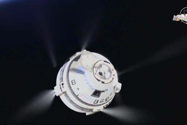 In this image from video provided by NASA, the unmanned Boeing Starliner capsule fires its thrusters as it pulls away from the International Space Station on Friday, Sept. 6, 2024. (NASA via AP)