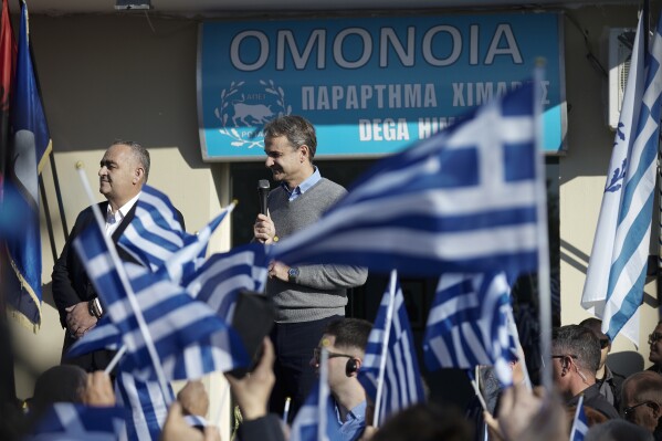 FILE - Greek Prime Minister Kyriakos Mitsotakis speaks next to Fredis Beleris, left, during his visit to the ethnic Greek minority of Albania, in Himare, on Thursday Dec. 22, 2022. Fredis Beleris, an ethnic Greek politician jailed in Albania for vote-buying, says he hopes his election this month to the European Parliament will help boost the rule of law in Albania. Beleris told The Associated Press in an interview from prison that he would have preferred to serve as mayor of the southern Albania community he was elected to lead last year, before his arrest and conviction. His case has soured relations between Balkan neighbors Greece and Albania. (Dimitris Papamitsos/Greek Prime Minister's Office via AP, File)