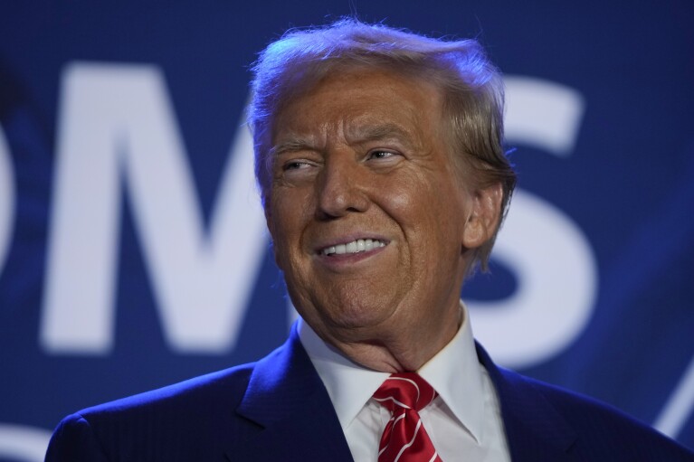 Republican presidential nominee former President Donald Trump arrives to speak with Moms for Liberty co-founder Tiffany Justice during an event at the group's annual convention in Washington, Friday, Aug. 30, 2024. (AP Photo/Mark Schiefelbein)