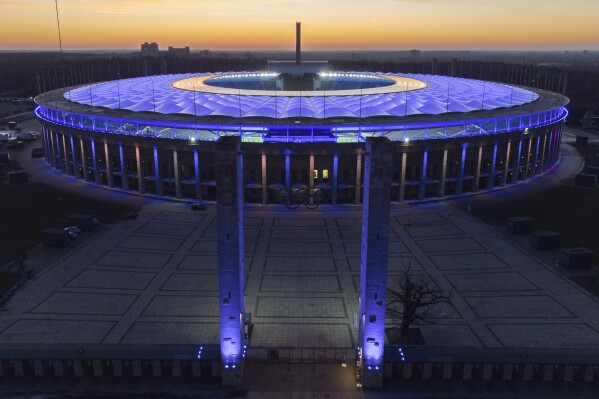 FILE - In this Feb. 21, 2021 file photo, the Olympic Stadium is illuminated as the sun sets after the German Bundesliga soccer match between Hertha BSC Berlin and RB Leipzig in Berlin, Germany. Scars of World War II and relics from its Nazi past are preserved at Berlin's Olympiastadion. When Spain plays England in the European Championship final, they will be playing in a stadium that doesn't hide it was built by the Nazis for the 1936 Olympic Games. (AP Photo/Michael Sohn, File)