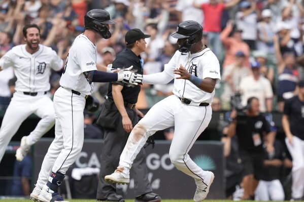 CORRECTS TO NINTH INNING FROM 10TH INNING - Detroit Tigers' Justyn-Henry Malloy is greeted at home after scoring to defeat the Los Angeles Dodgers in the ninth inning of a baseball game, Sunday, July 14, 2024, in Detroit. (AP Photo/Carlos Osorio)