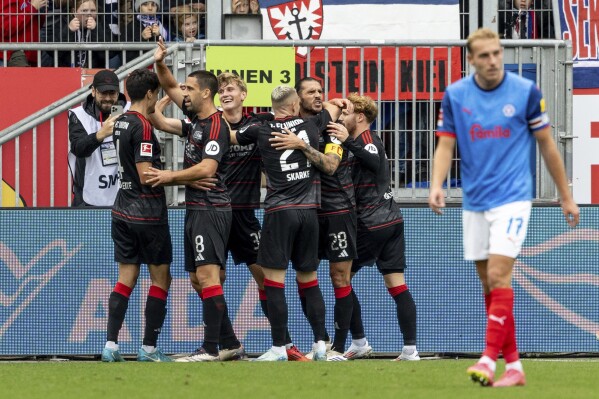 Berlin's Aljoscha Kemlein, 3rd left, celebrates scoring with teammates during the Bundesliga soccer match between Holstein Kiel and 1. FC Union Berlin at Holstein Stadium, Kiel, Germany, Sunday Oct. 20, 2024. (Axel Heimken/dpa via AP)