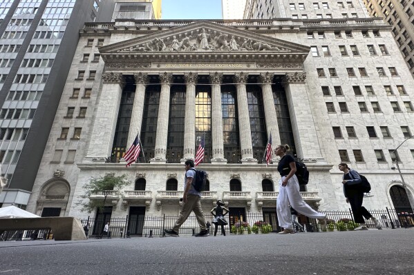 People pass the New York Stock Exchange on Wednesday, Sept. 4, 2024, in New York. (AP Photo/Peter Morgan)