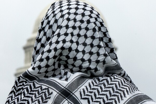 FILE - A man wearing a keffiyeh looks at the U.S. Capitol during a pro-Palestinian rally, on May 18, 2024, on the National Mall in Washington. At the graduation ceremony of New York University Abu Dhabi in May, 2024, a student wearing the traditional Palestinian black-and-white keffiyeh scarf shouted “Free Palestine!” as he crossed the stage to receive his diploma, witnesses say. Days later, he reportedly was deported from the United Arab Emirates. (AP Photo/Jacquelyn Martin, File)