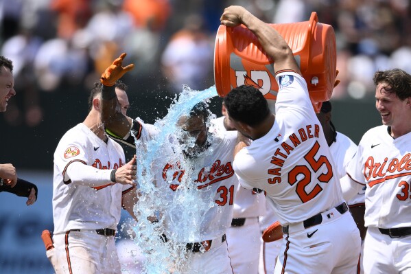Baltimore Orioles' Cedric Mullins (31) gets doused by Anthony Santander (25) after Mullins hit a two RBI walk-off double to win a baseball game against the New York Yankees, Sunday, July 14, 2024, in Baltimore. The Orioles won 6-5. (AP Photo/Nick Wass)