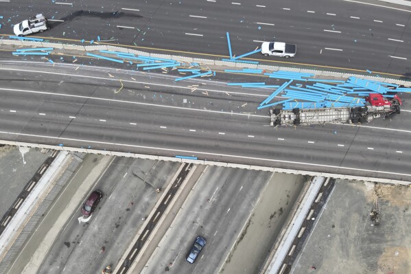 This drone photo provided by the Wheat Ridge Police Department shows where a semitruck overturned, killing a newlywed couple and the bride's mother just days after the wedding, on Interstate 70 west of Denver, Thursday, Aug. 15, 2024. (Wheat Ridge Police Department via AP)