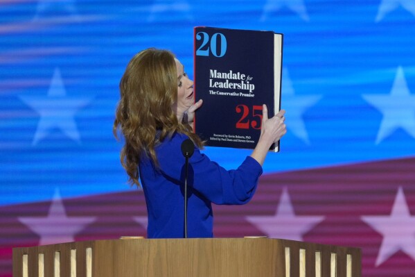 Michigan State Senator Mallory McMorrow holding up a book during her remarks at the Democratic National Convention on Monday, Aug. 19, 2024, in Chicago. (AP Photo/J. Scott Applewhite)