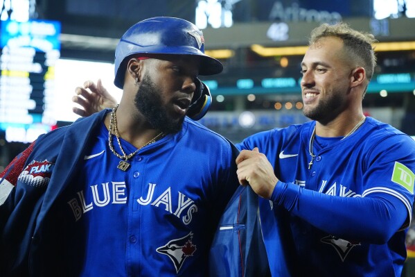 Toronto Blue Jays' Vladimir Guerrero Jr., left, celebrates his home run against the Arizona Diamondbacks with Blue Jays' George Springer during the seventh inning of a baseball game, Sunday, July 14, 2024, in Phoenix. (AP Photo/Ross D. Franklin)