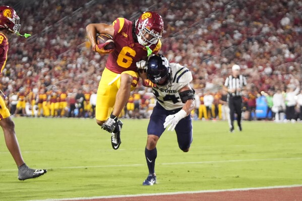 Southern California wide receiver Makai Lemon, left, jumps in for a touchdown as Utah State safety Jordan Vincent defends during the first half of an NCAA college football game, Saturday, Sept. 7, 2024, in Los Angeles. (AP Photo/Mark J. Terrill)