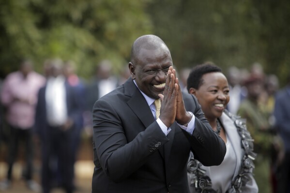 FILE - Kenya's President William Ruto gestures to party officials as he walks with his wife Rachel Ruto as he prepares to address the media at his official residence in Nairobi, Kenya Monday, Sept. 5, 2022. The ballooning debt in East Africa's economic hub of Kenya is expected to grow even more after deadly protests forced the rejection of a finance bill that President William Ruto said was needed to raise revenue. He now warns “it will have huge consequences.” (AP Photo/Brian Inganga, File)